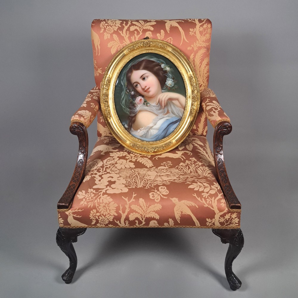 An oval nineteenth-century oil portrait depicting a young woman with flowers in her hair, encased in an ornate gold giltwood frame. View II