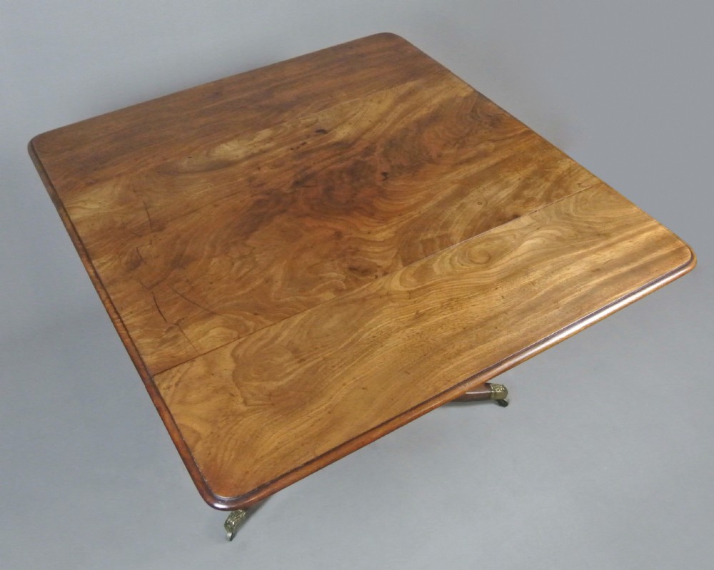 A George III Cuban mahogany Pembroke table featuring two hinged drop leaves, a central turned stem support, and four splayed legs with brass castors. View VII