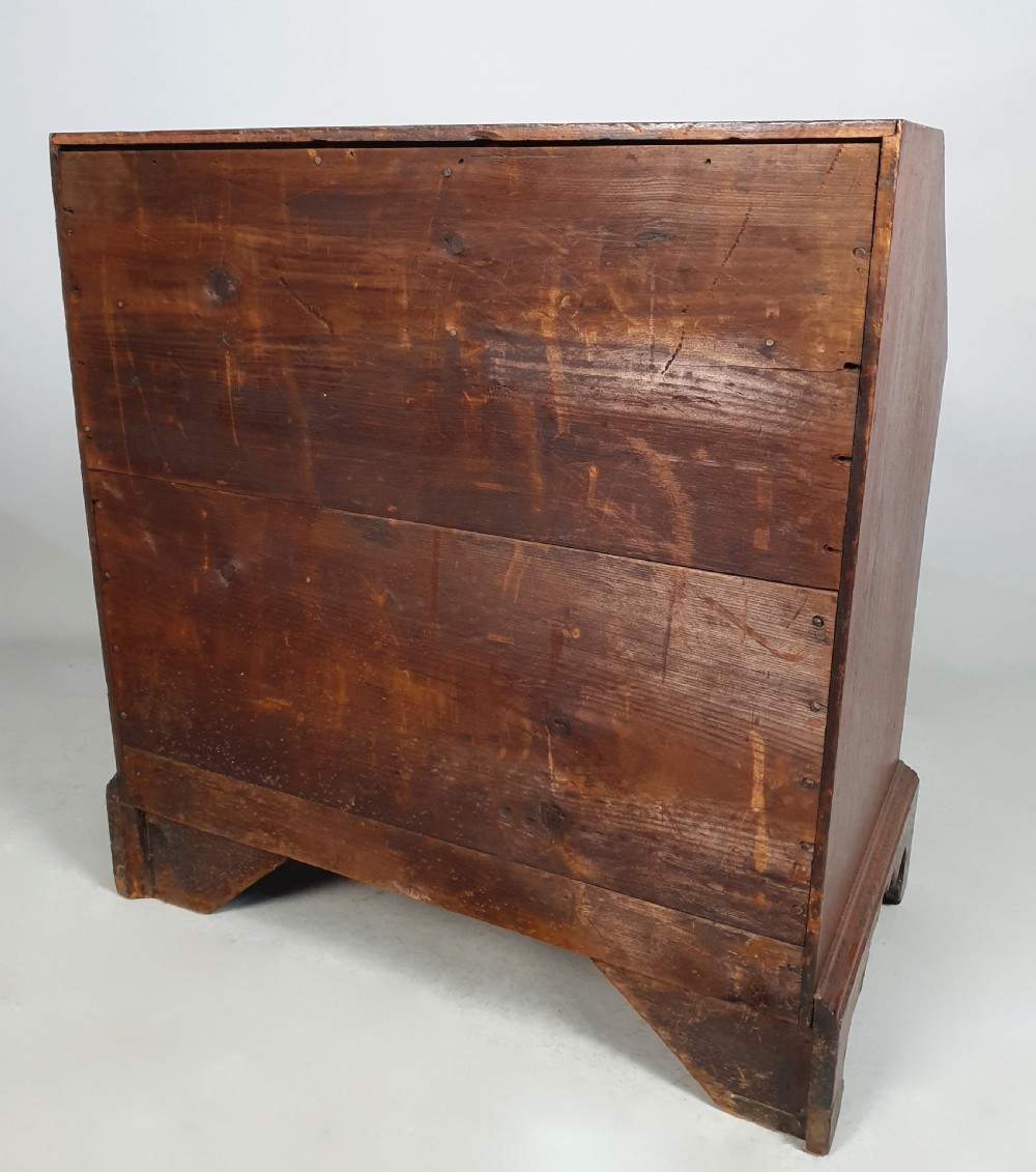 An 18th-century George II fruitwood slant-front bureau shown open, displaying fitted internal pigeonholes, small drawers, and brass hardware. View VII