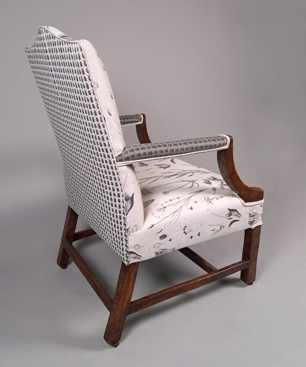 A George III yew wood Gainsborough armchair featuring monochrome botanical fabric upholstery, padded armrests, square legs, and brass castors. View VII