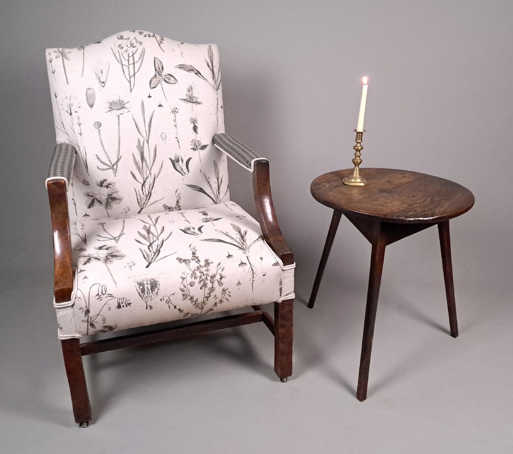 A George III yew wood Gainsborough armchair featuring monochrome botanical fabric upholstery, padded armrests, square legs, and brass castors. View VIII
