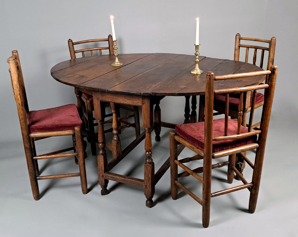 An early 18th-century oak gateleg table featuring an oval drop-leaf top, turned baluster legs, and lower box stretchers. View II
