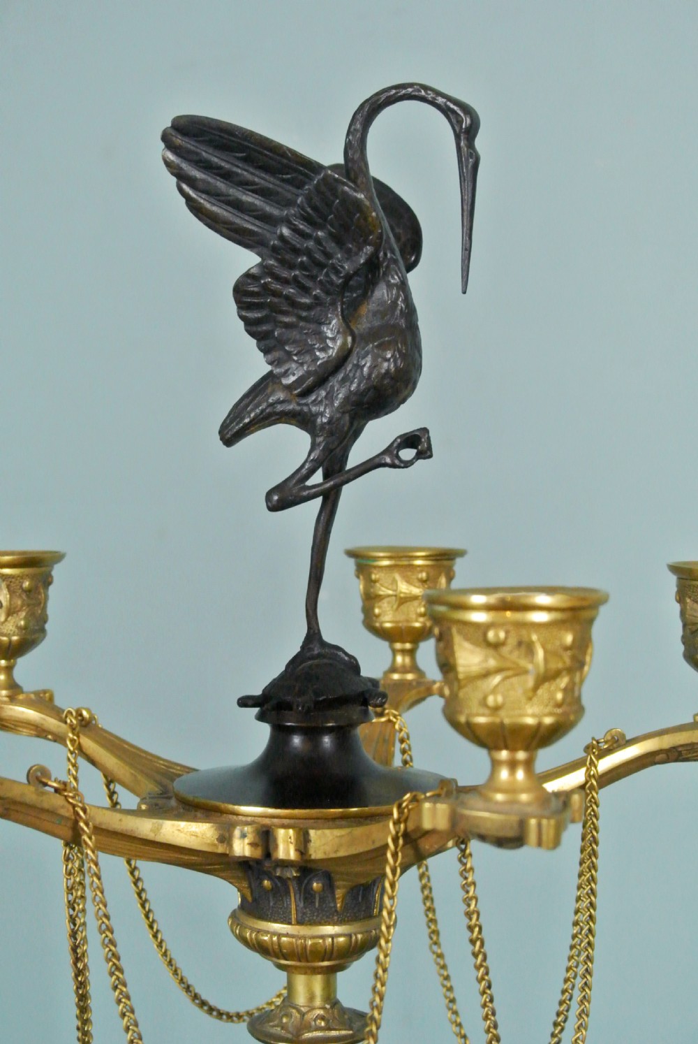 A pair of tall nineteenth-century dark bronze and gilded ormolu candelabra featuring crane finials, hanging chains, multi-nozzle arms, and tripod claw bases. View VI