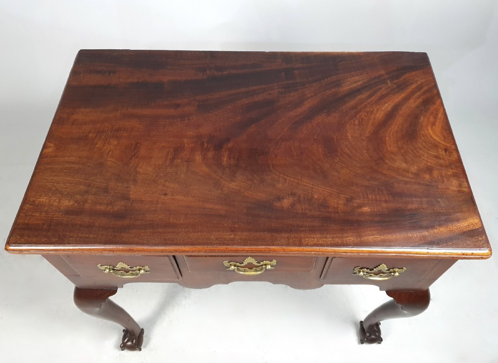 An 18th-century George III red walnut lowboy table with three brass-handled drawers, a shaped apron, and front cabriole legs ending in carved ball-and-claw feet. View V