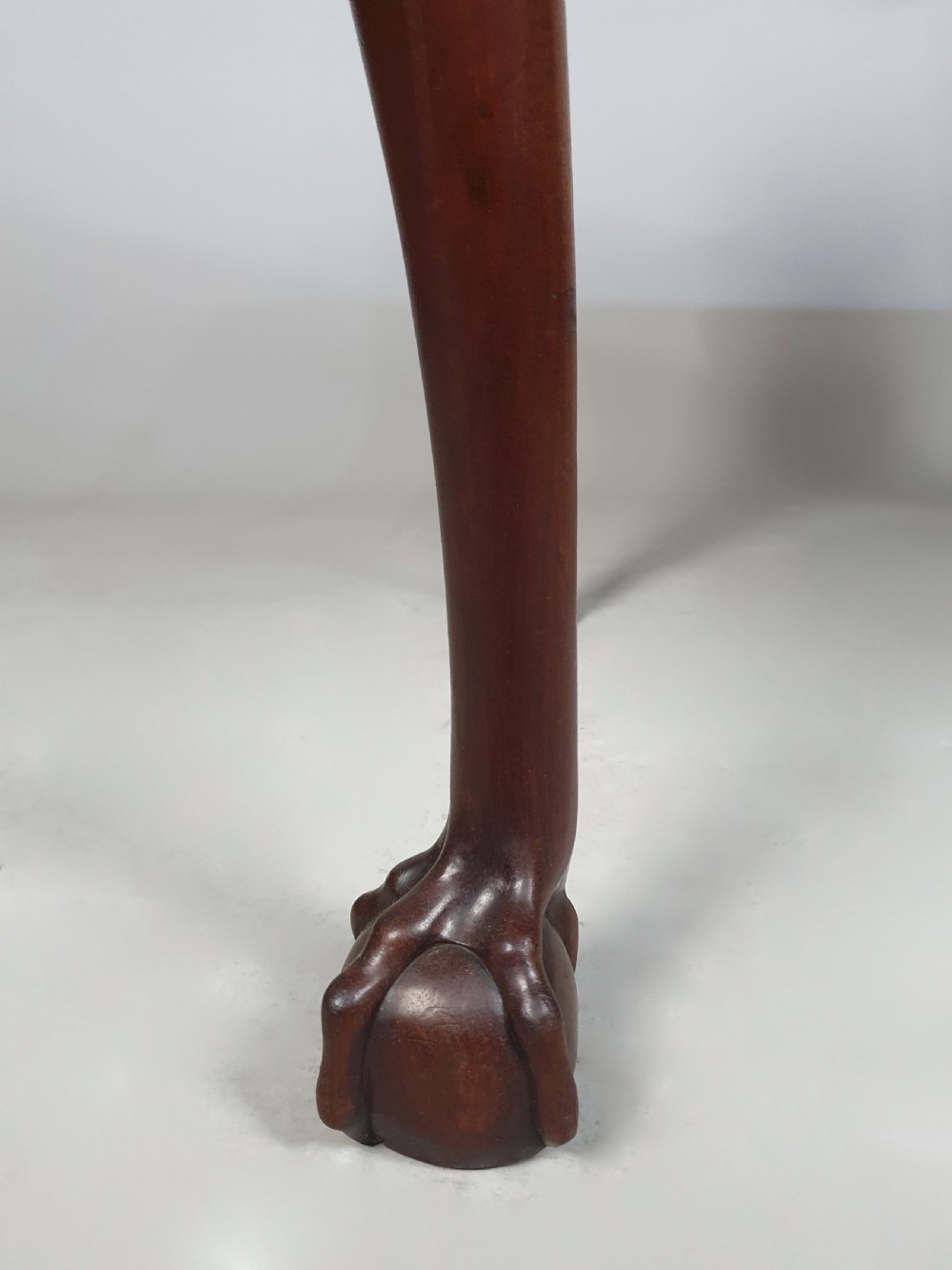 An 18th-century George III red walnut lowboy table with three brass-handled drawers, a shaped apron, and front cabriole legs ending in carved ball-and-claw feet. View VI