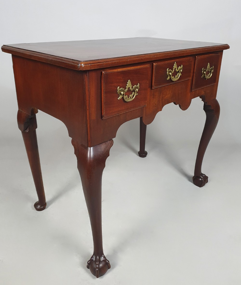 An 18th-century George III red walnut lowboy table with three brass-handled drawers, a shaped apron, and front cabriole legs ending in carved ball-and-claw feet. View VIII
