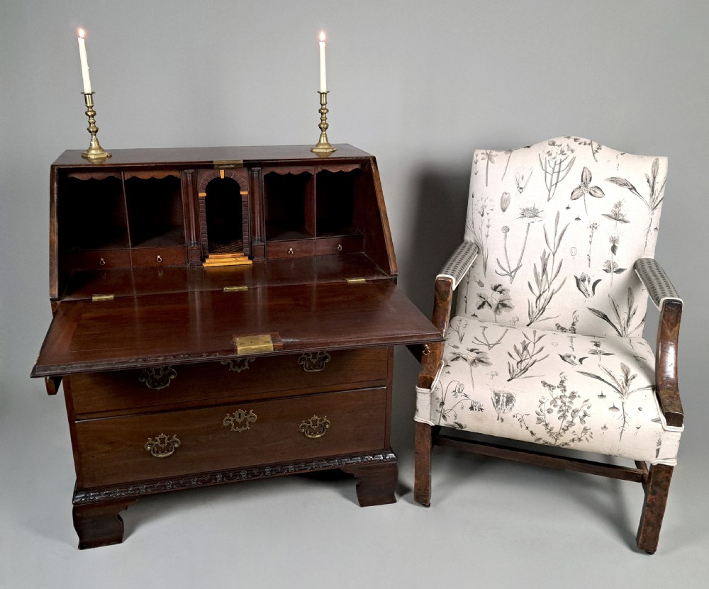 An eighteenth-century Chippendale style dark padauk wood writing bureau featuring an open fall-front writing surface, architectural pigeonhole section, brass handles, and bracket feet. View III