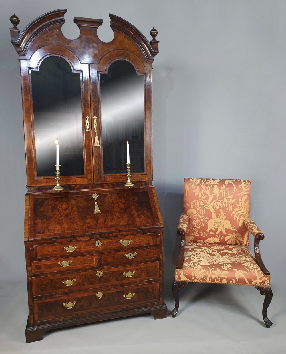 An early 18th-century Queen Anne burr walnut bureau cabinet featuring a double-domed pediment, open doors revealing multiple pigeonholes, a sloped drop-front writing desk, and lower storage drawers. View II