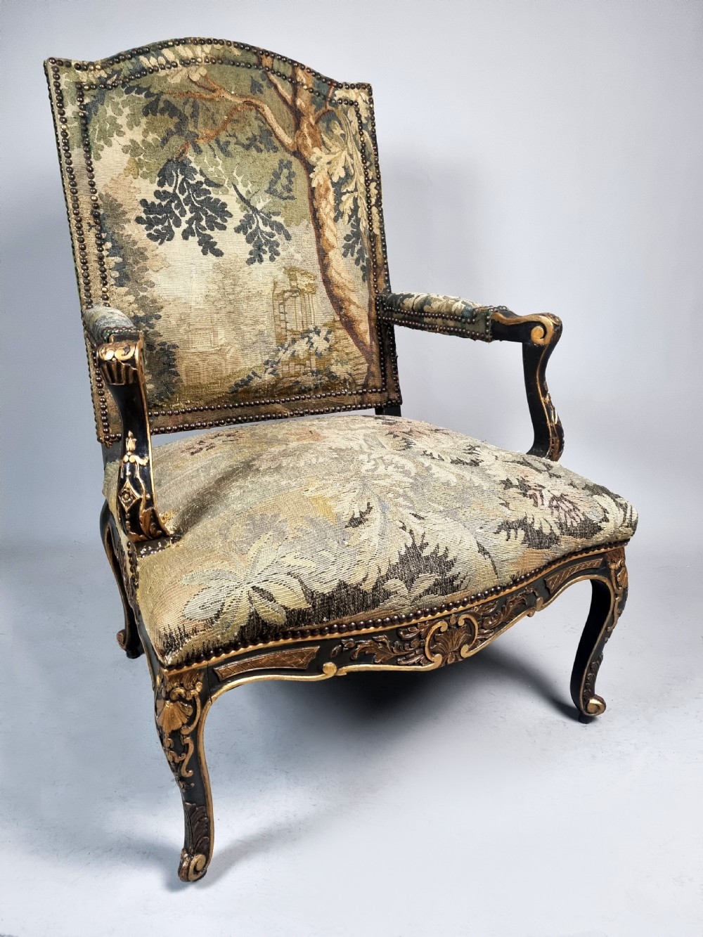 A George III Gainsborough armchair with carved cabriole legs, parcel gilding, and green landscape tapestry upholstery trimmed with brass studs. View III