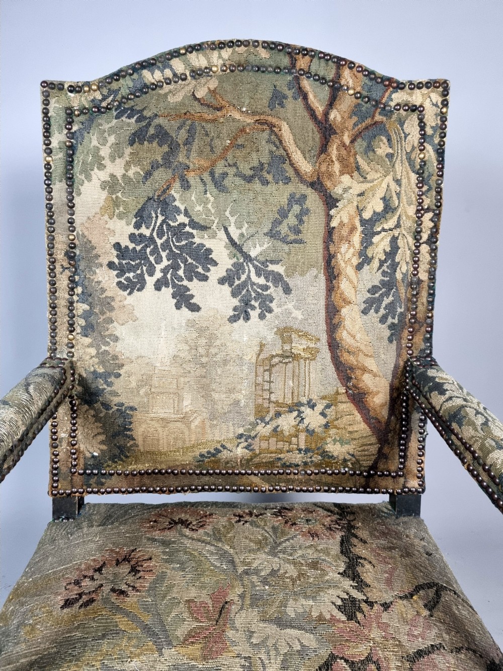 A George III Gainsborough armchair with carved cabriole legs, parcel gilding, and green landscape tapestry upholstery trimmed with brass studs. View IV