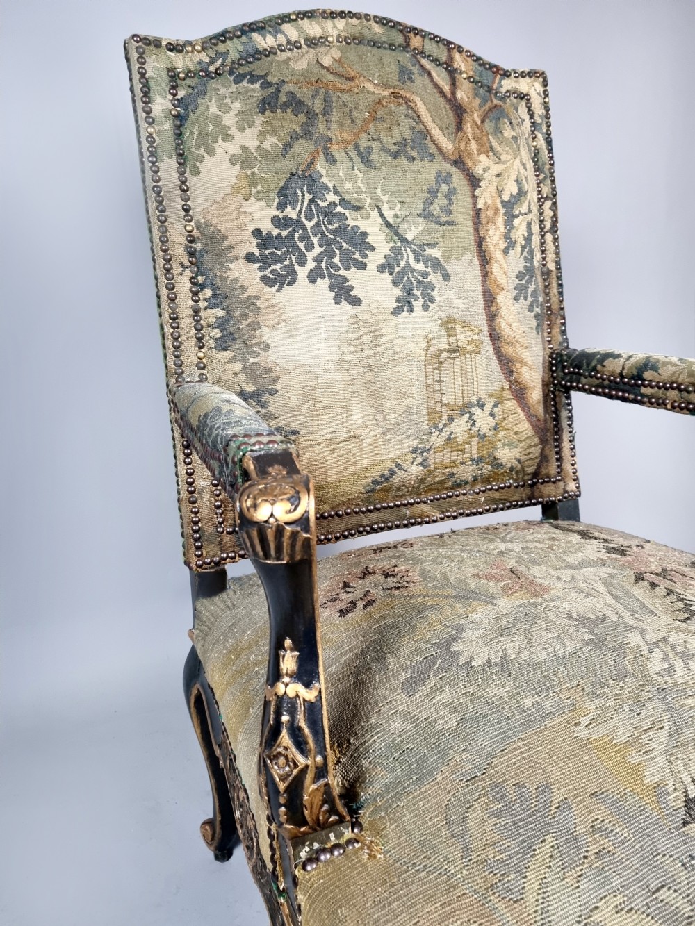 A George III Gainsborough armchair with carved cabriole legs, parcel gilding, and green landscape tapestry upholstery trimmed with brass studs. View V