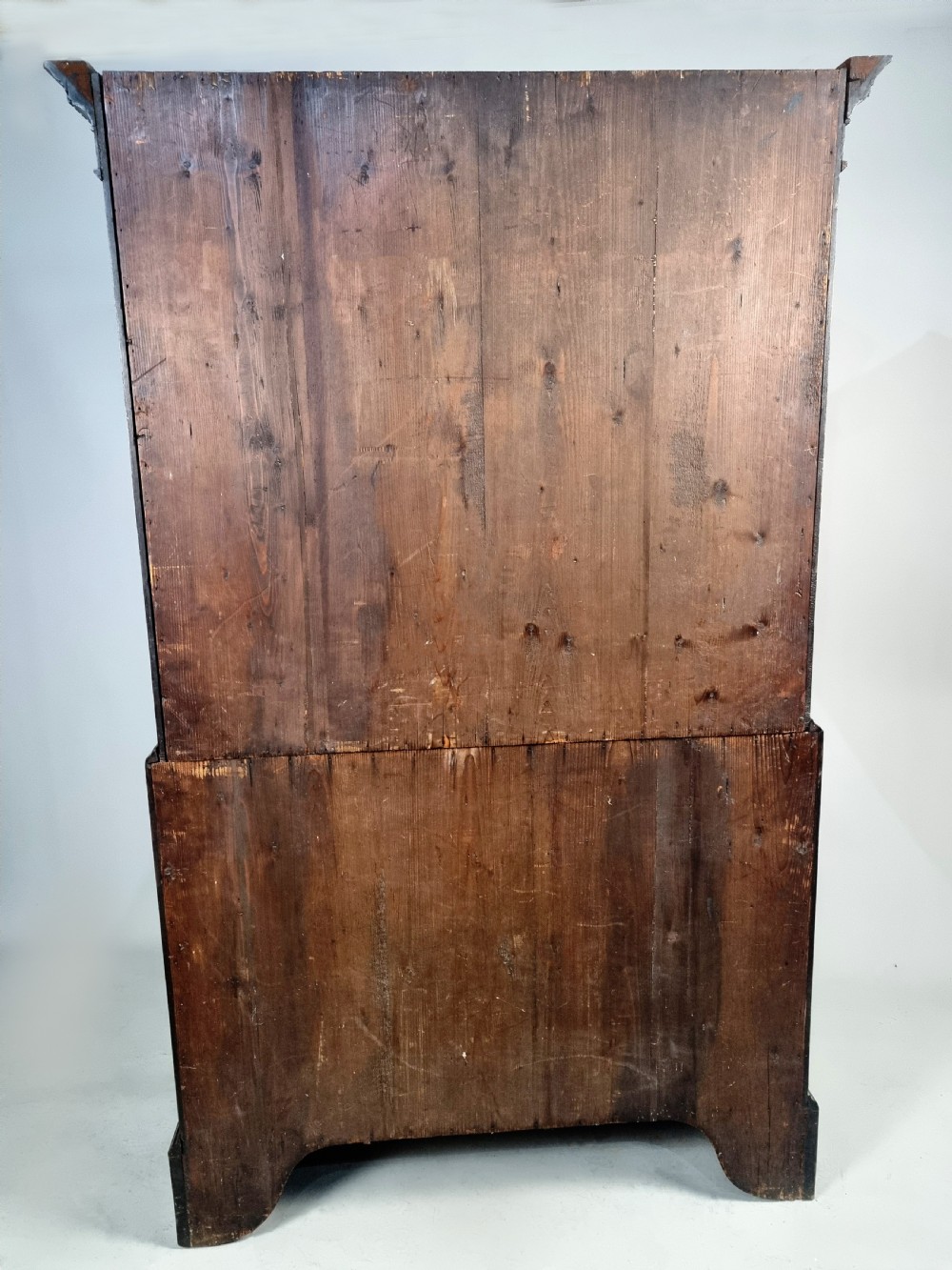 A tall George III mahogany chest on chest featuring stacked drawer sections, pierced brass handles, carved fretwork at the frieze, and bracket feet. View VI