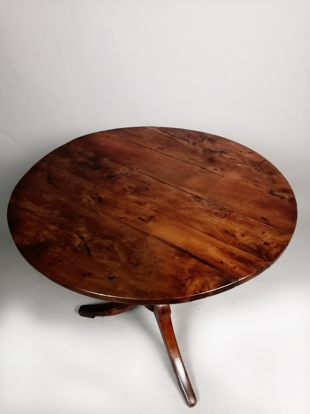 A Georgian yew wood wine table featuring a circular tilt top displaying natural grain patterns, set on a turned central pedestal with three splayed legs. View III