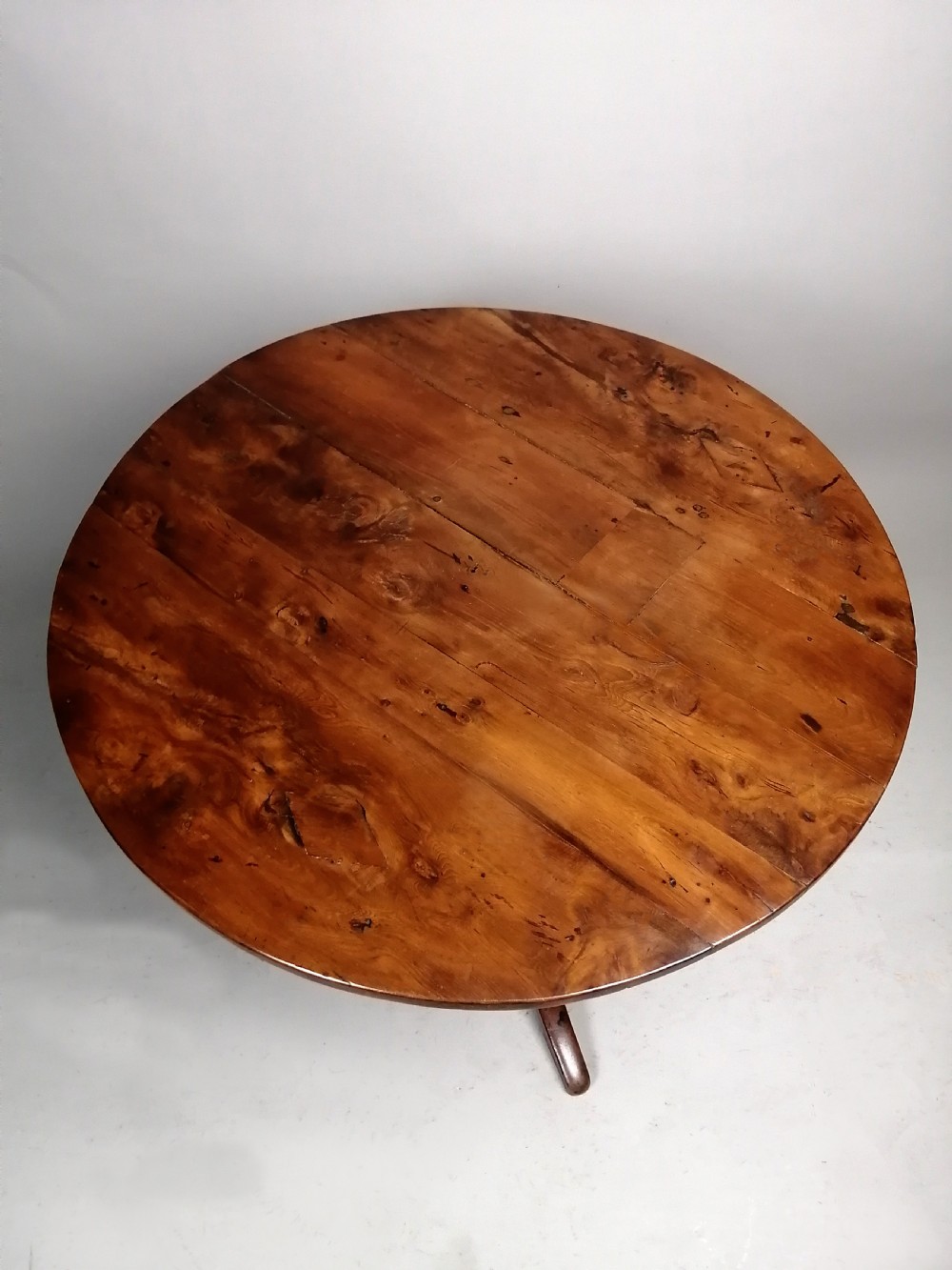 A Georgian yew wood wine table featuring a circular tilt top displaying natural grain patterns, set on a turned central pedestal with three splayed legs. View IV