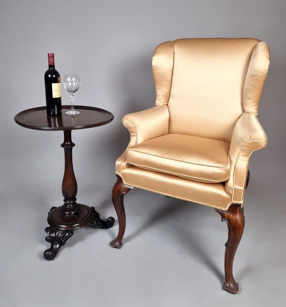 A William IV mahogany wine table featuring a dished circular top, turned central pedestal column, and a carved triform base with scroll feet. View II