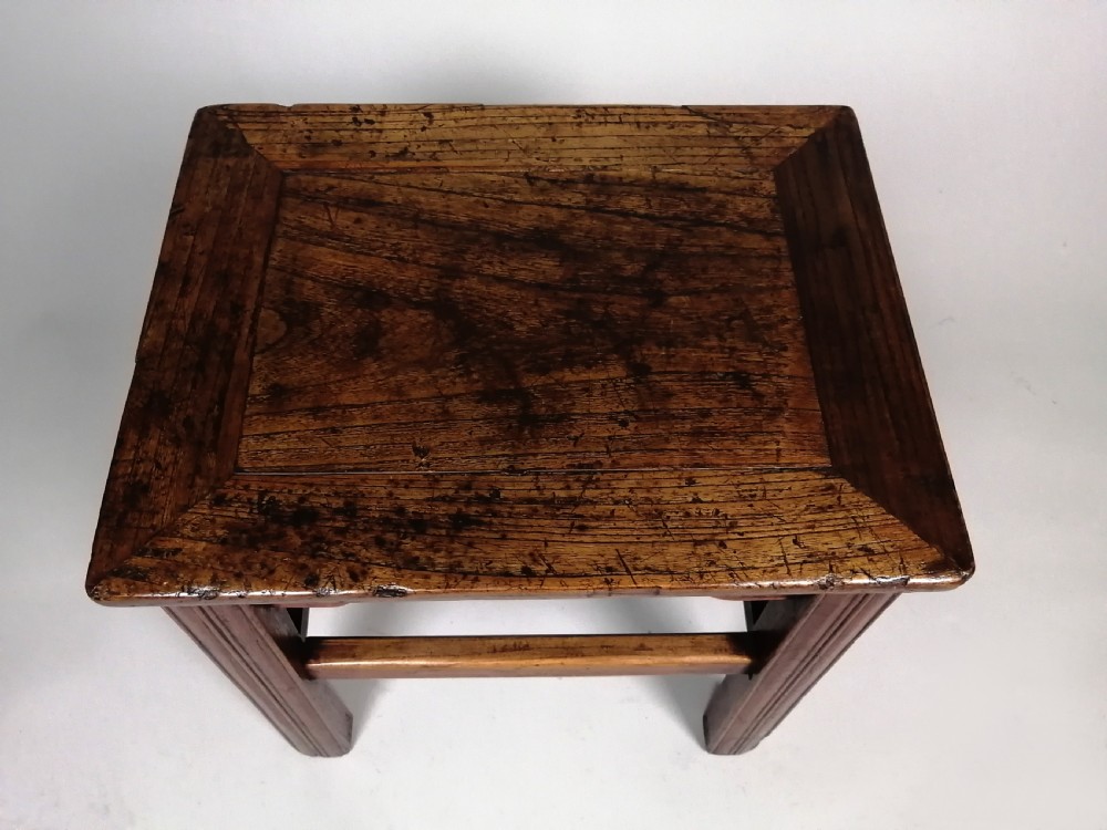 An 18th-century Chinese elm side table featuring a rectangular framed top, shaped apron spandrels, fluted legs, and double stretchers. View V