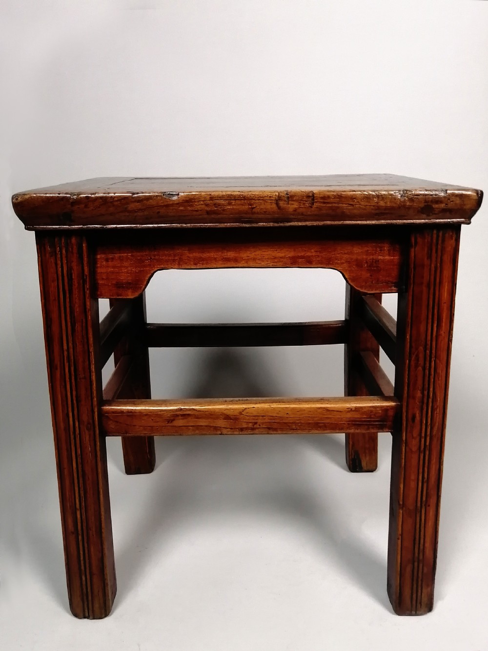 An 18th-century Chinese elm side table featuring a rectangular framed top, shaped apron spandrels, fluted legs, and double stretchers. View VI