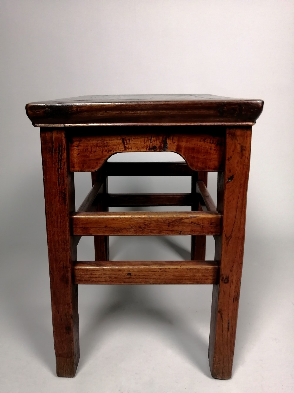 An 18th-century Chinese elm side table featuring a rectangular framed top, shaped apron spandrels, fluted legs, and double stretchers. View VII