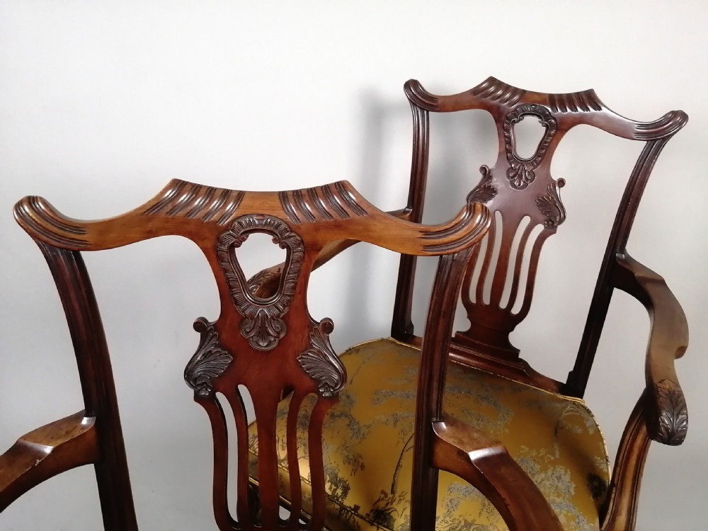 A pair of late Victorian mahogany elbow chairs featuring carved lyre back splats, curved arms, cabriole legs, and gold patterned upholstered seats. View IX