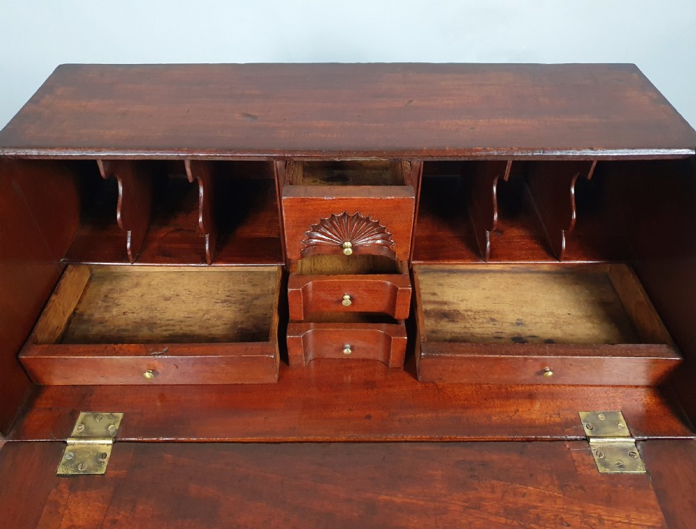An 18th-century George II slant-front writing bureau made of warm brown fruitwood with brass drop handles and bracket feet. View V