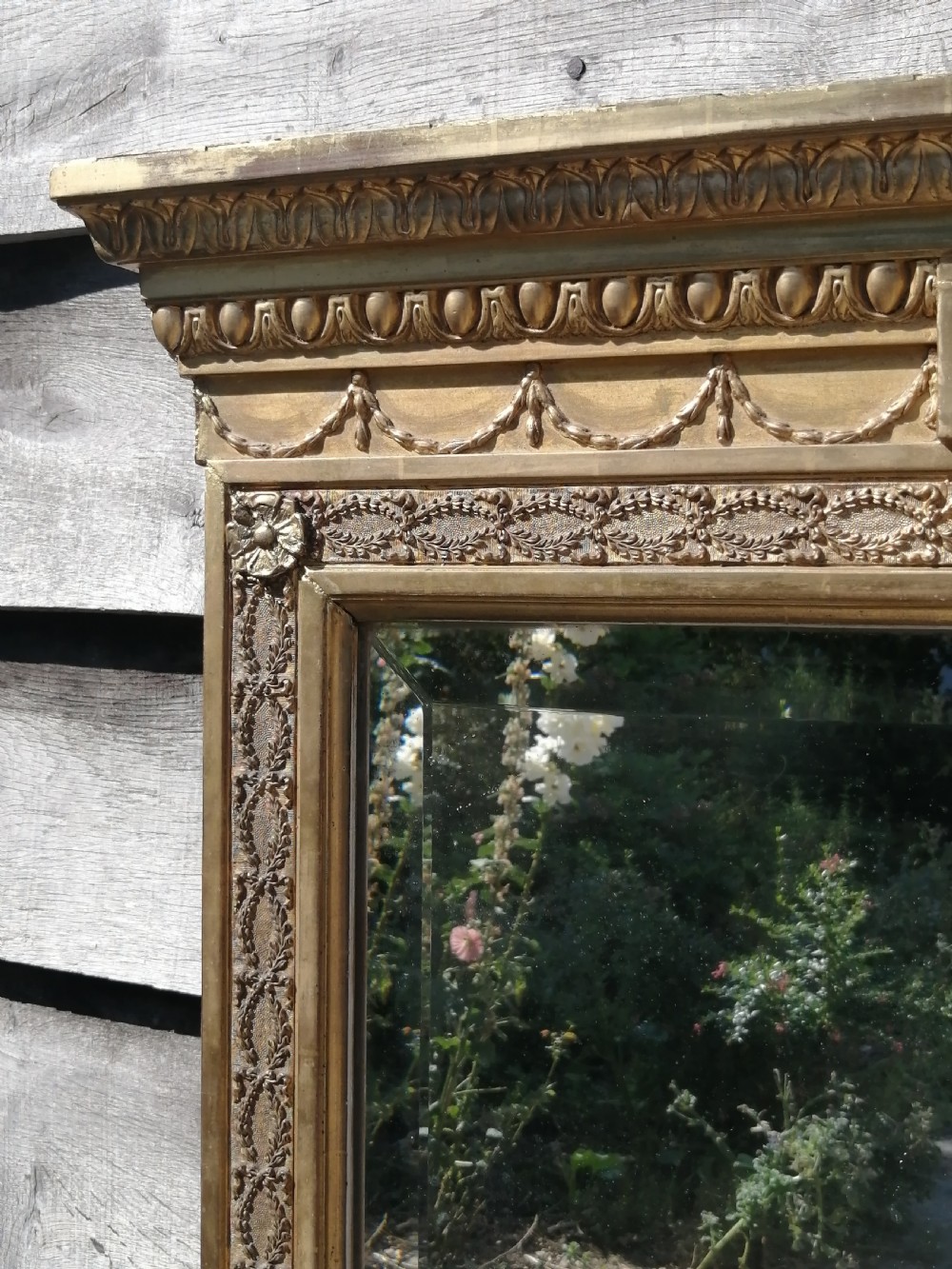 A tall rectangular Regency giltwood pier mirror featuring a carved classical frieze, fluted side pilasters, and a reflective glass plate. View V
