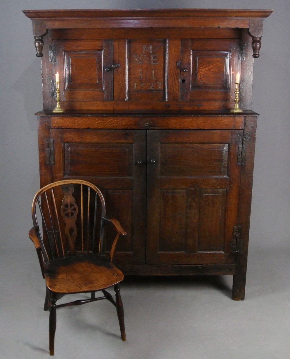 An 18th-century dark oak court cupboard featuring a carved date of 1723, upper recessed cabinet with drop finials, and fielded lower door panels. View III