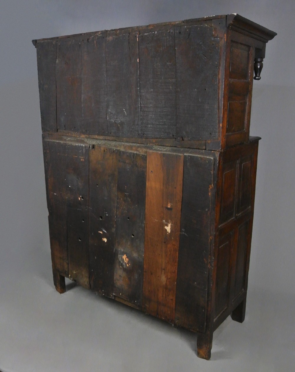 An 18th-century dark oak court cupboard featuring a carved date of 1723, upper recessed cabinet with drop finials, and fielded lower door panels. View VIII