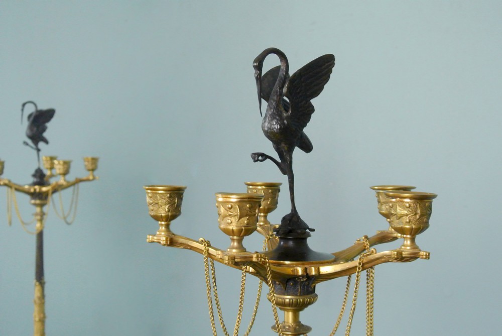 A pair of late nineteenth-century French ormolu and patinated bronze multi-light candelabra topped with crane figures and hung with small gilt chains. View V