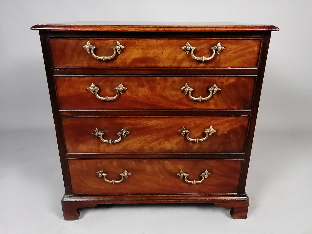 A compact George III Cuban mahogany chest of drawers featuring four graduated drawers with brass swan-neck handles and bracket feet. View VI