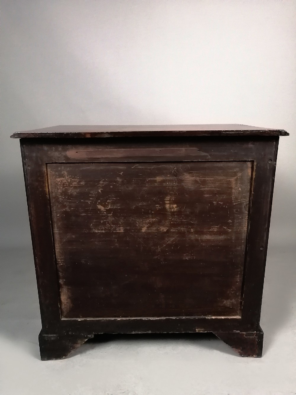 A compact George III Cuban mahogany chest of drawers featuring four graduated drawers with brass swan-neck handles and bracket feet. View X