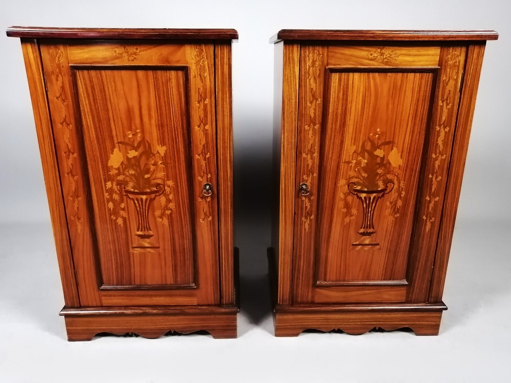 A matching pair of late 19th-century rosewood bedside cabinets featuring detailed floral marquetry inlays on the central door panels.