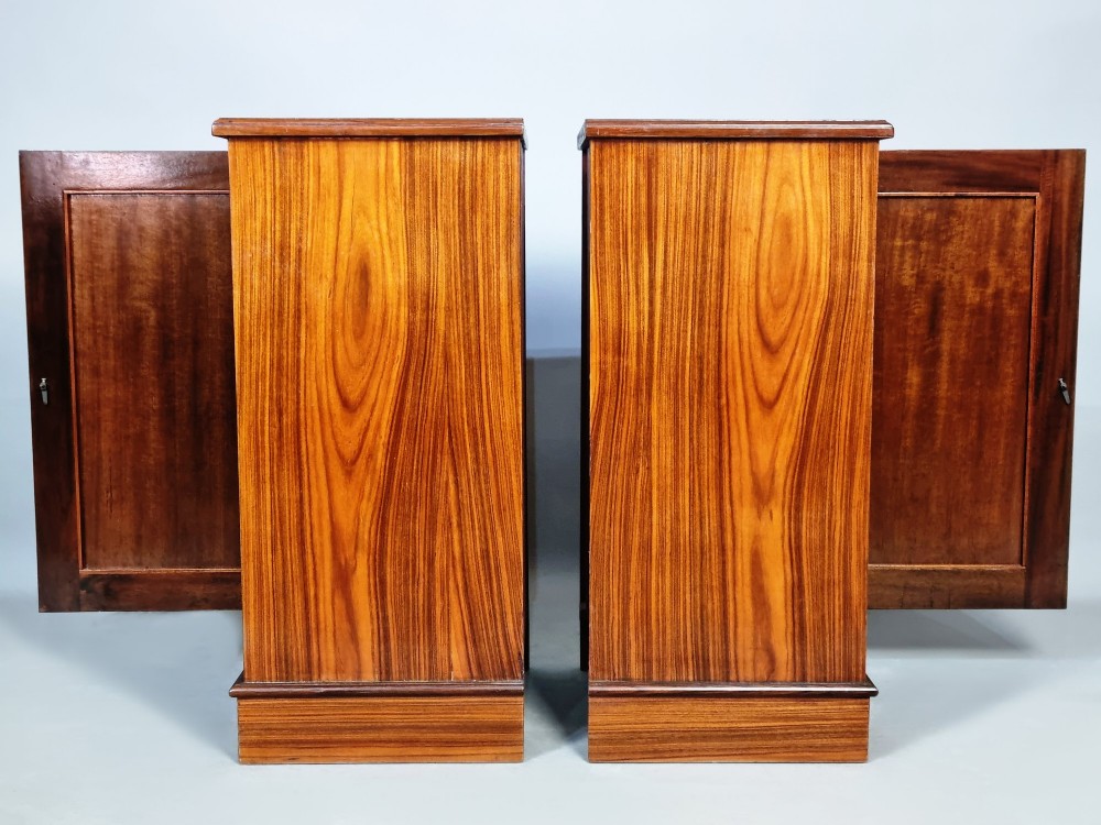 A matching pair of late 19th-century rosewood bedside cabinets featuring detailed floral marquetry inlays on the central door panels. View V
