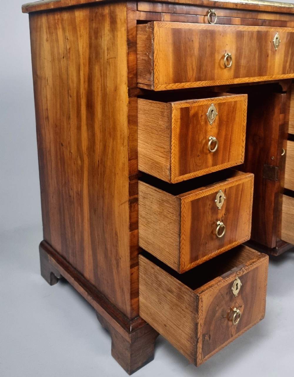An 18th-century George II yew wood kneehole dressing table with multiple drawers, brass drop handles, and a central recessed cupboard. View V