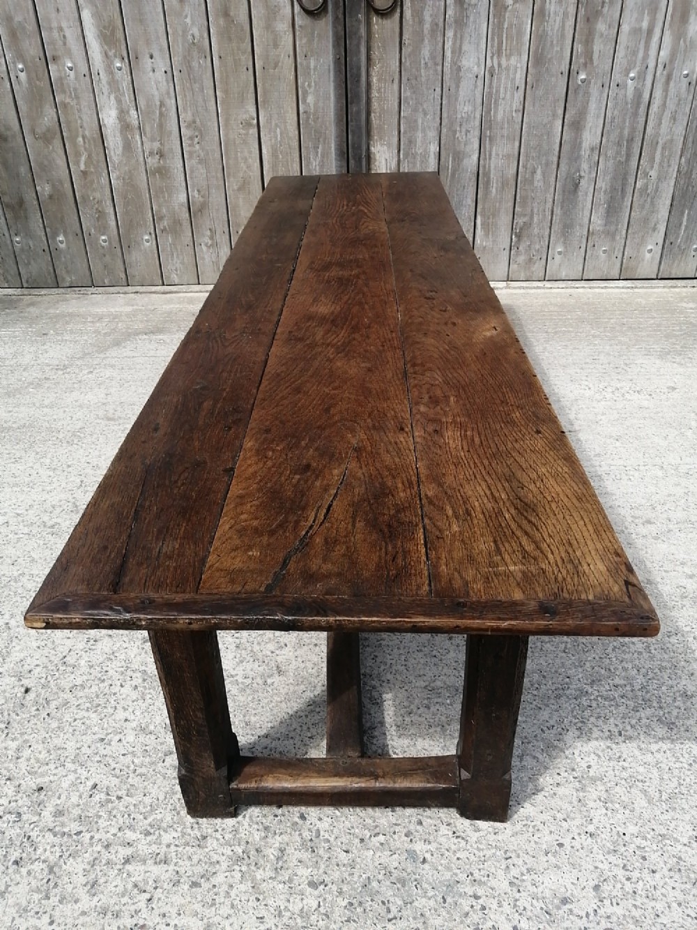 A long George I oak and elm refectory table featuring a plank top and low stretcher base. View VII
