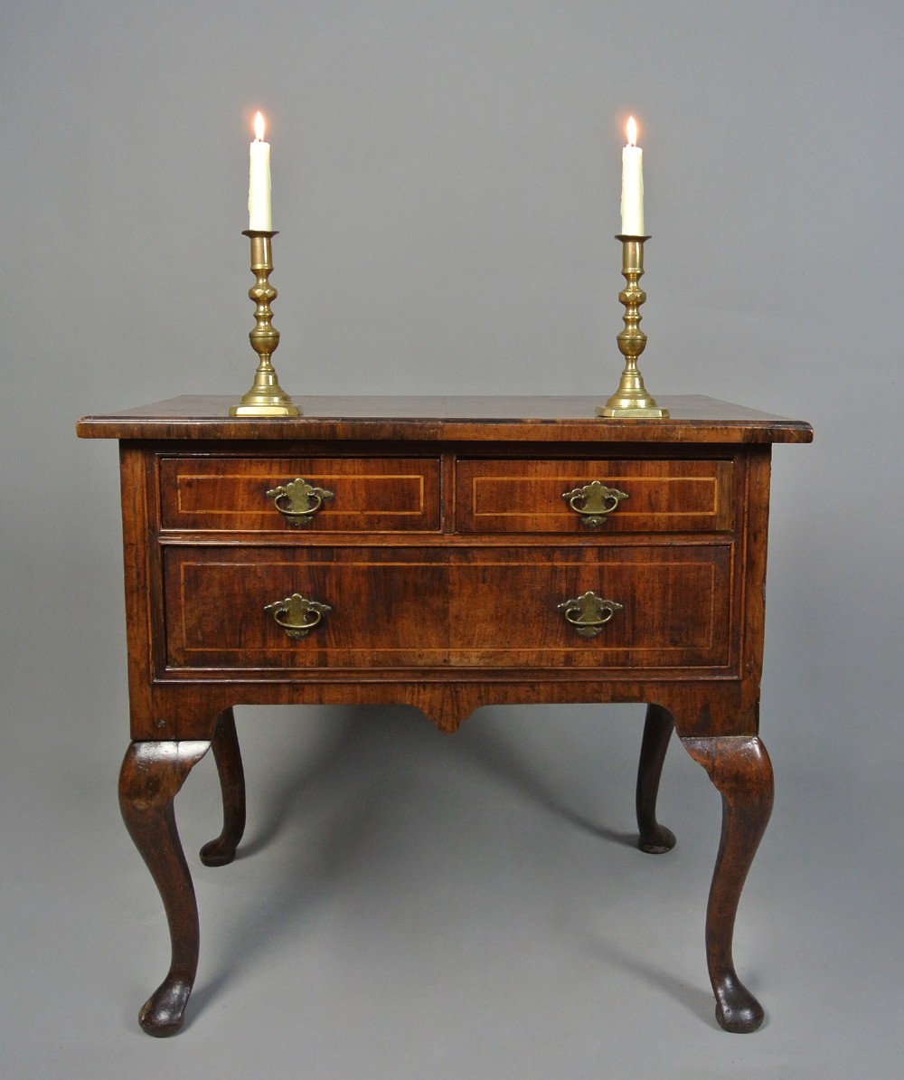 A George I walnut lowboy table featuring three featherbanded drawers with brass handles, cabriole legs, pad feet, and a shaped apron. View VI