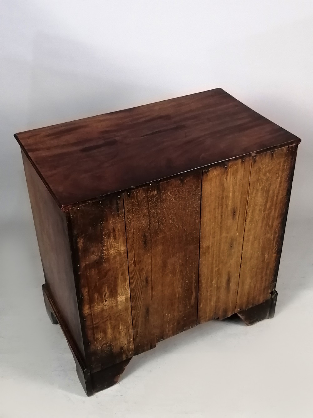 An 18th-century Georgian mahogany kneehole desk featuring multiple drawers with brass handles, bracket feet, and a central cupboard door. View X