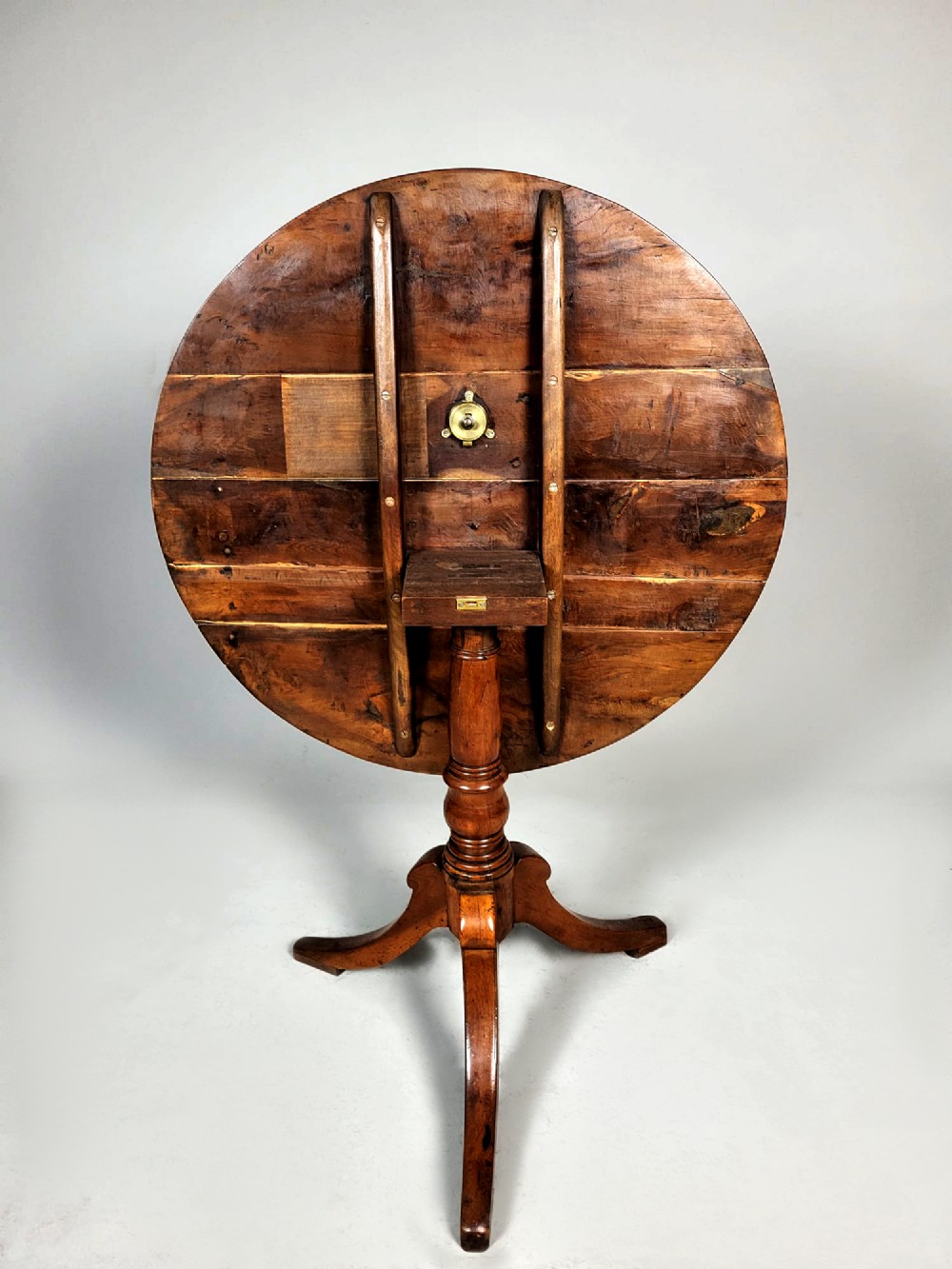 A Georgian yew wood circular tilt-top wine table featuring a turned central pedestal and a tripod base. View II