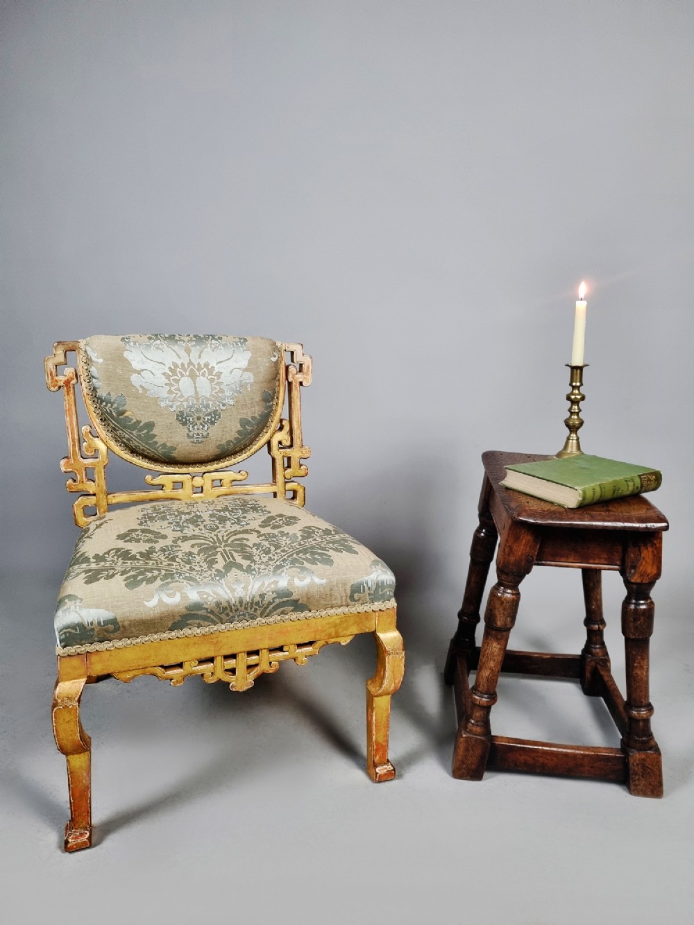 A 19th-century Chinese Chippendale style giltwood side chair featuring carved fretwork and damask upholstery. View II