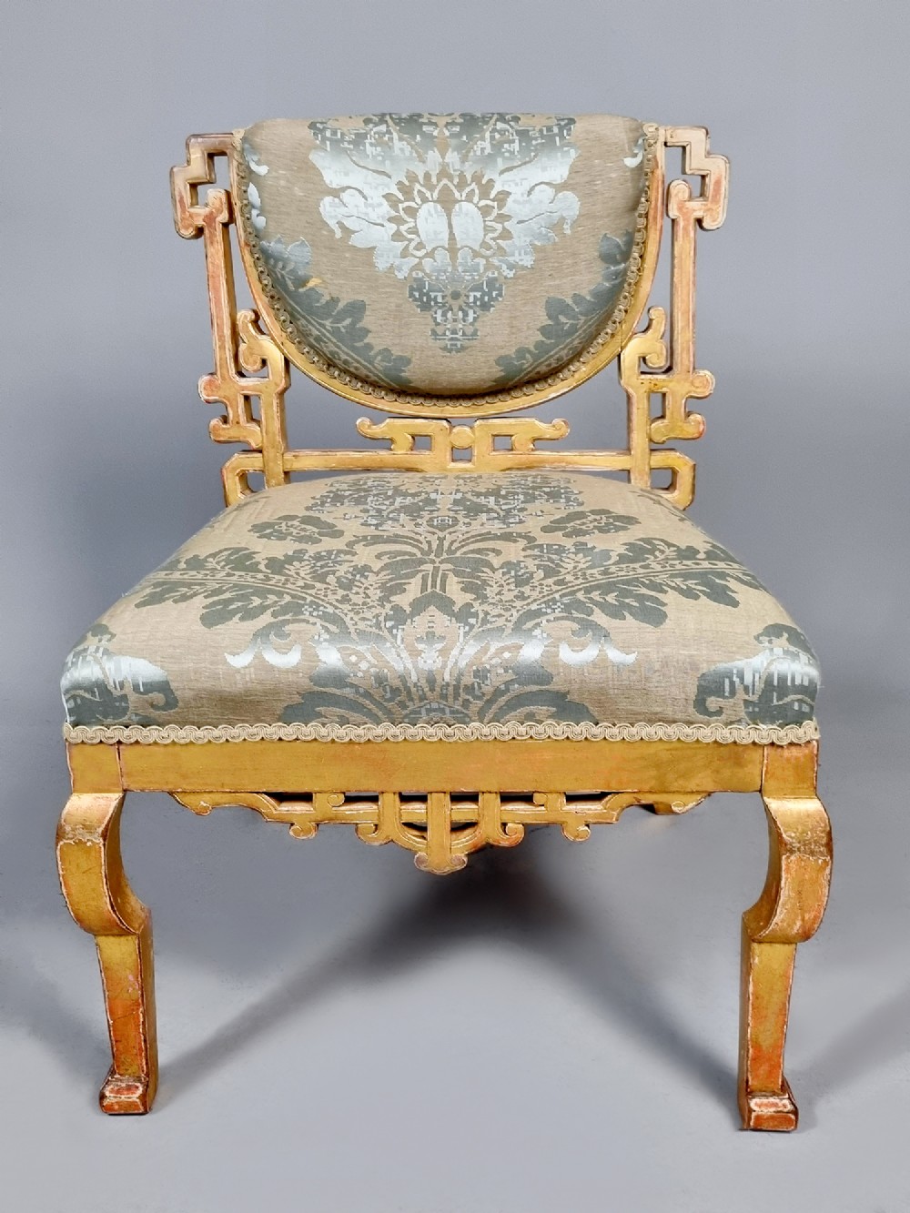 A 19th-century Chinese Chippendale style giltwood side chair featuring carved fretwork and damask upholstery. View III