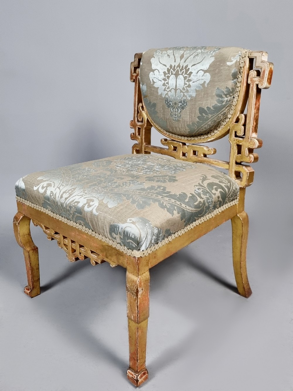 A 19th-century Chinese Chippendale style giltwood side chair featuring carved fretwork and damask upholstery. View IV