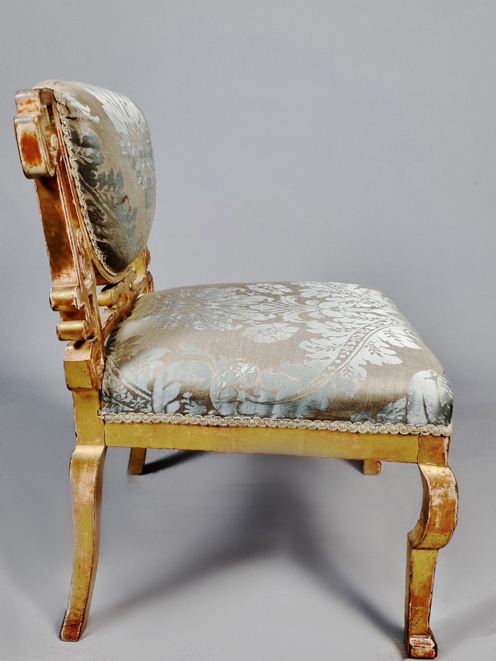 A 19th-century Chinese Chippendale style giltwood side chair featuring carved fretwork and damask upholstery. View VII
