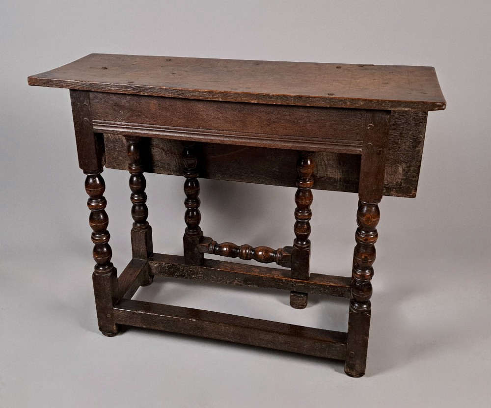 A 17th-century Charles II dark oak drop-leaf side table with turned legs and a low box stretcher base. View VI