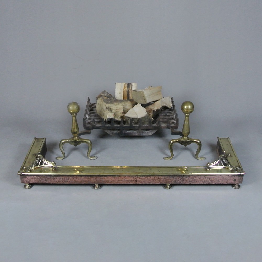 An Art Nouveau fire fender made of hammered copper with a polished brass top rail, corner mounts, and small rounded feet. View II