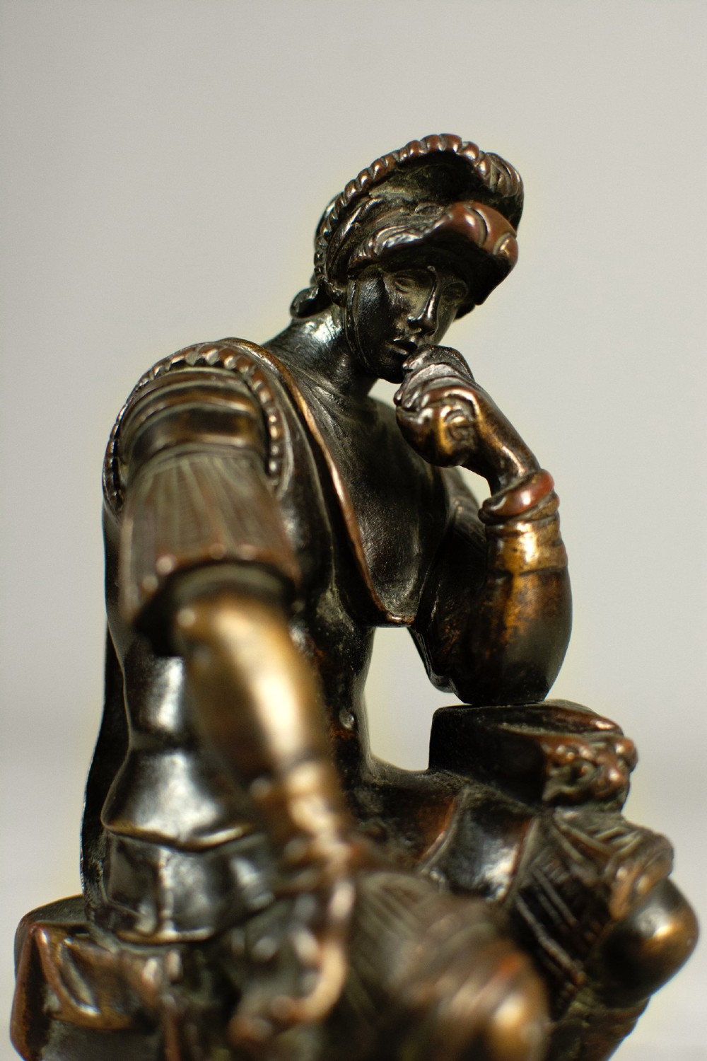 A dark patinated bronze figure depicting Lorenzo de Medici seated in a thoughtful pose on a rectangular base. View V