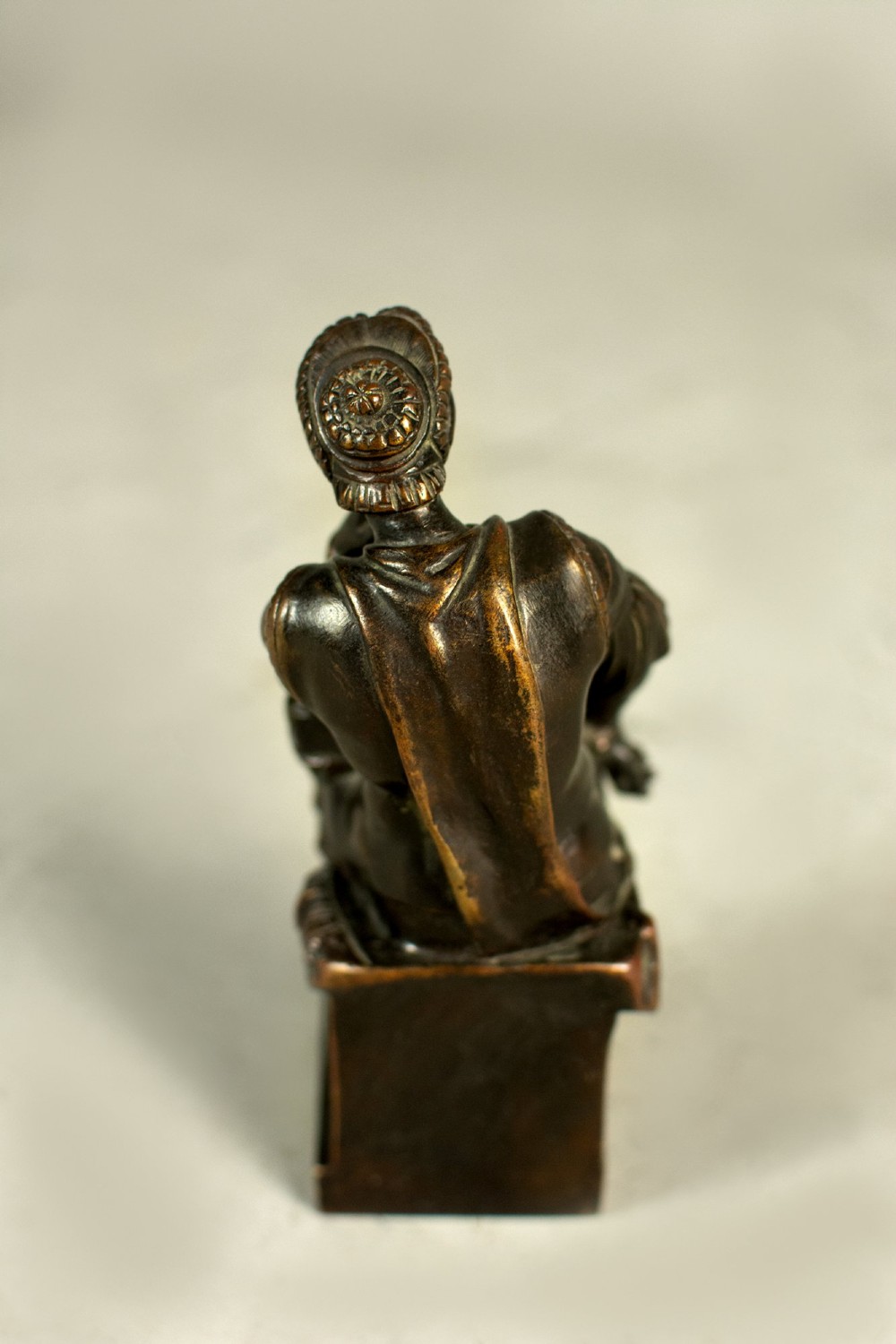 A dark patinated bronze figure depicting Lorenzo de Medici seated in a thoughtful pose on a rectangular base. View VII