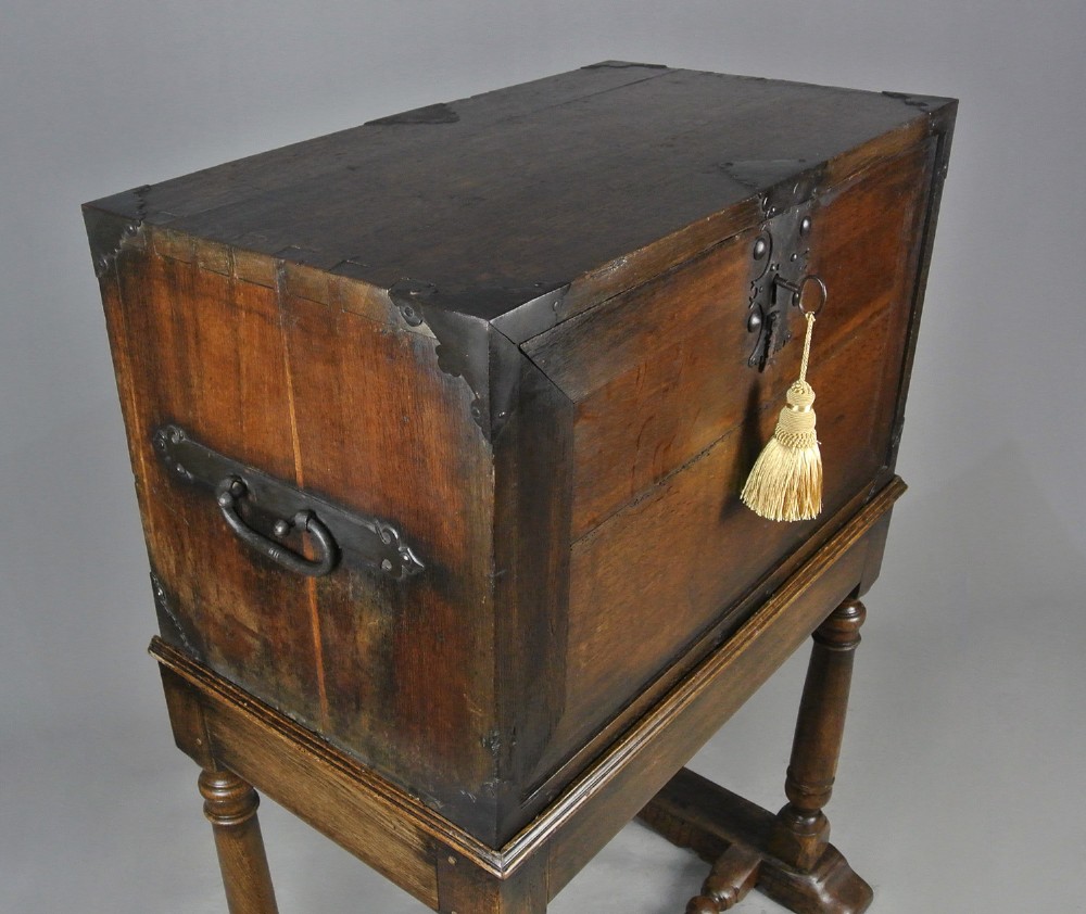 A seventeenth-century dark oak fall-front writing desk on a turned leg stand with interior drawers and wrought iron corner brackets. View V