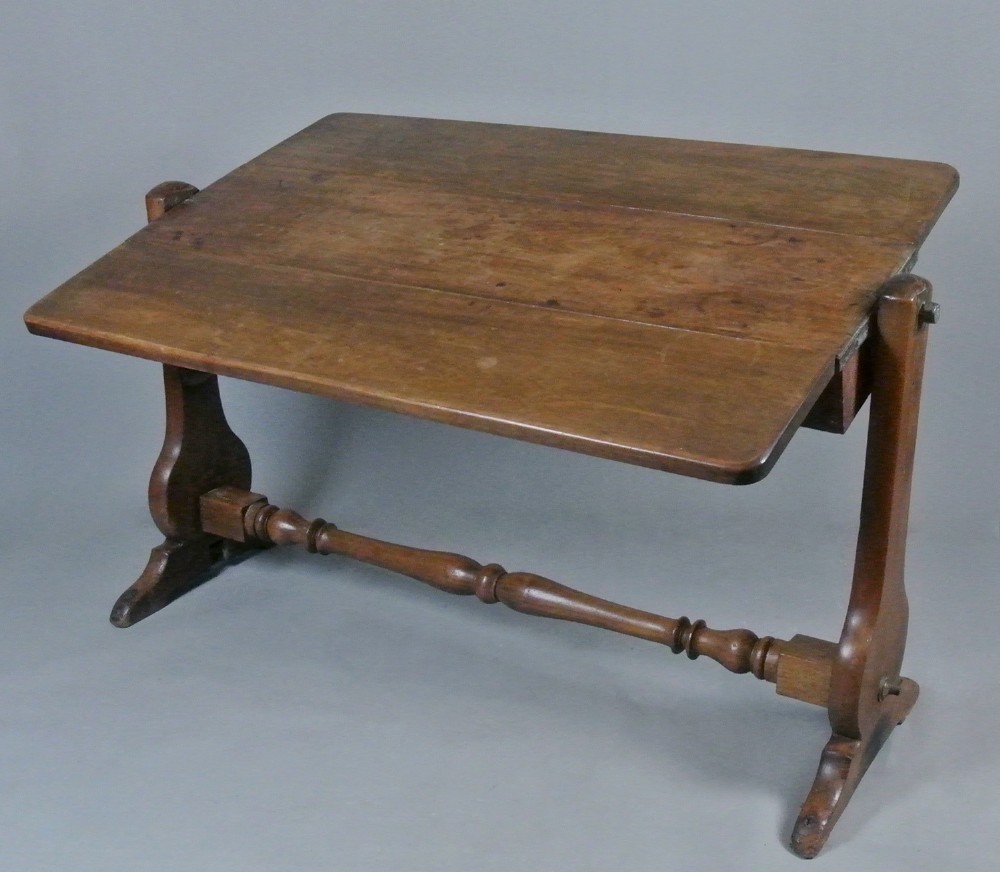 An 18th-century Georgian solid teak campaign table featuring a tilting rectangular top, a turned cross stretcher, and trestle end supports. View V