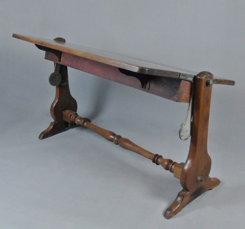 An 18th-century Georgian solid teak campaign table featuring a tilting rectangular top, a turned cross stretcher, and trestle end supports. View VI