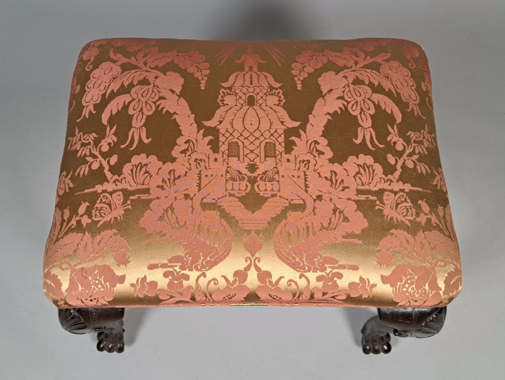 An 18th-century Irish George II mahogany footstool with shell-carved cabriole legs, claw and ball feet, and patterned damask top. View III