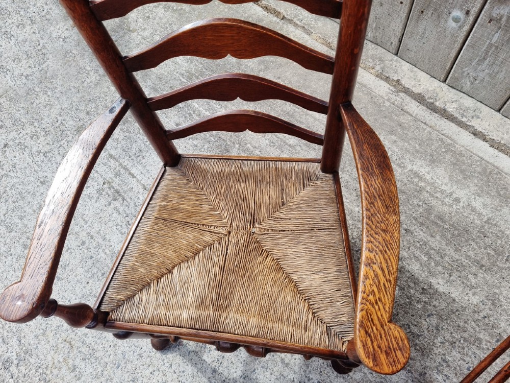 A set of eight 19th-century wooden country dining chairs featuring woven rush seats with green seat pads, shaped horizontal back slats, and turned legs. View IX